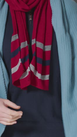 Vertical-Video-Close-Up-Of-Person-Wearing-Blanket-Scarf-And-Hat-Trying-To-Keep-Warm-In-Energy-Crisis